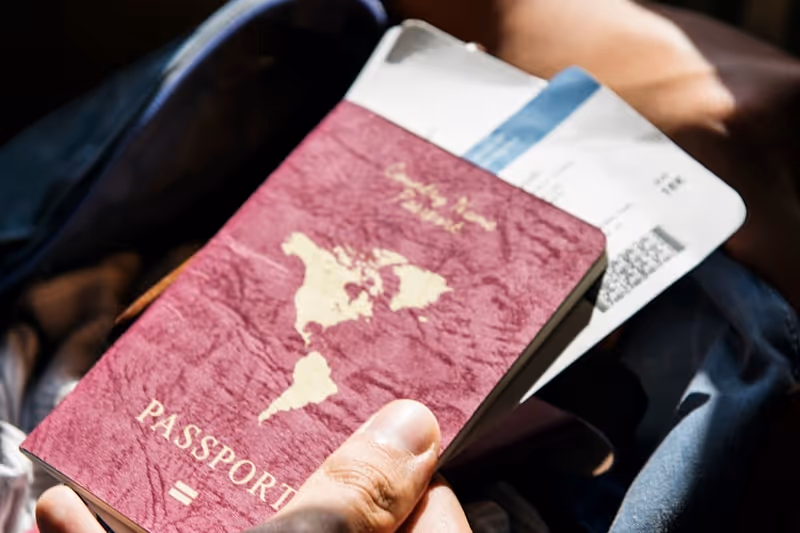 Passeport et billets d'avion posés sur une surface, prêts pour le voyage