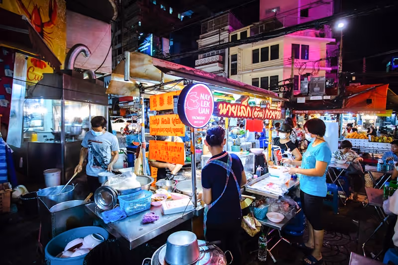 Stand de street food à Bangkok avec un cuisinier préparant des nouilles